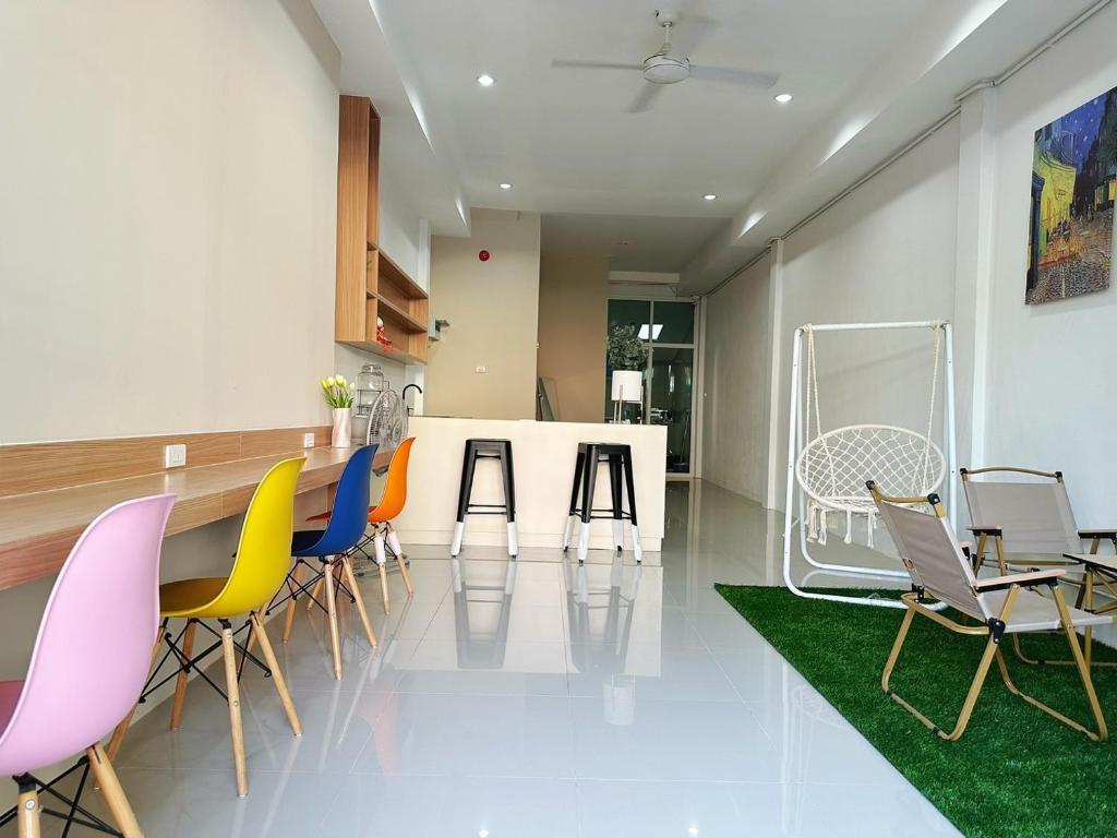 a kitchen with colorful chairs and a table at BeHome and Hostel in Chiang Mai