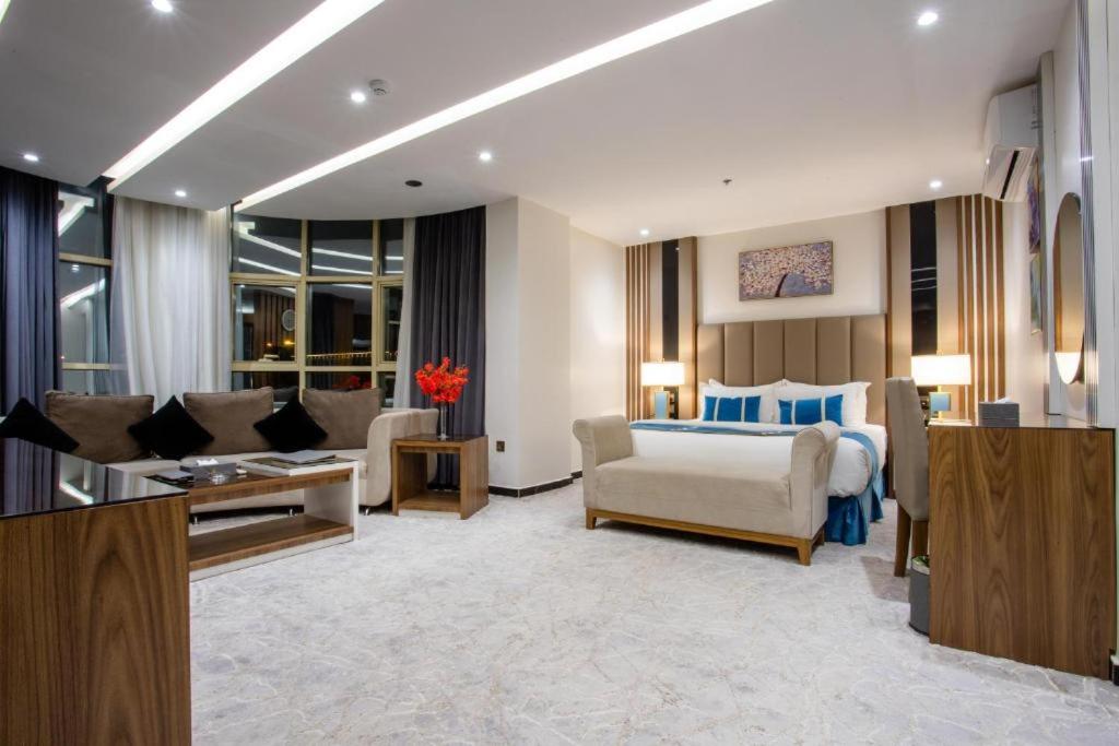 una camera con letto e un soggiorno con divano di جولدن بوجاري الضيافه a Khamis Mushayt