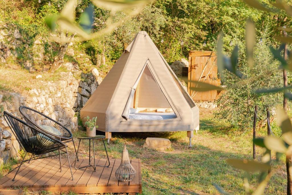 uma tenda num quintal com uma mesa e cadeiras em Tipì - Glamping Experience em Chiusanico