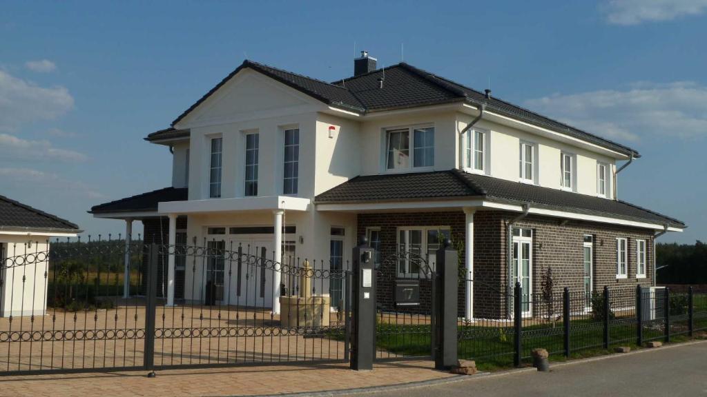 a white house with a fence in front of it at Villa Toskana Rothenburg in Linden