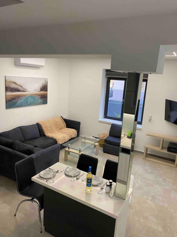 a living room with a couch and a table at Ivory Style Maisonette near Downtown in Heraklio