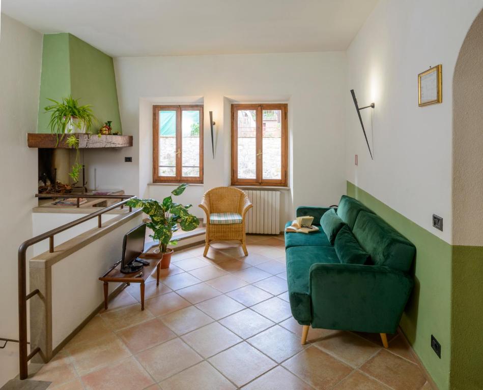 salon z zieloną kanapą i stołem w obiekcie Donna Nobile w mieście San Gimignano