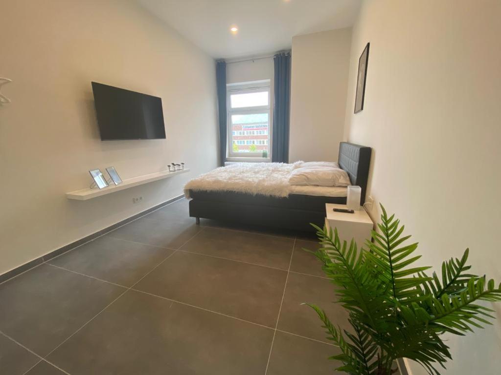 1 dormitorio con 1 cama y TV en la pared en Ferienwohnung PIER 4 in Cuxhaven, en Cuxhaven