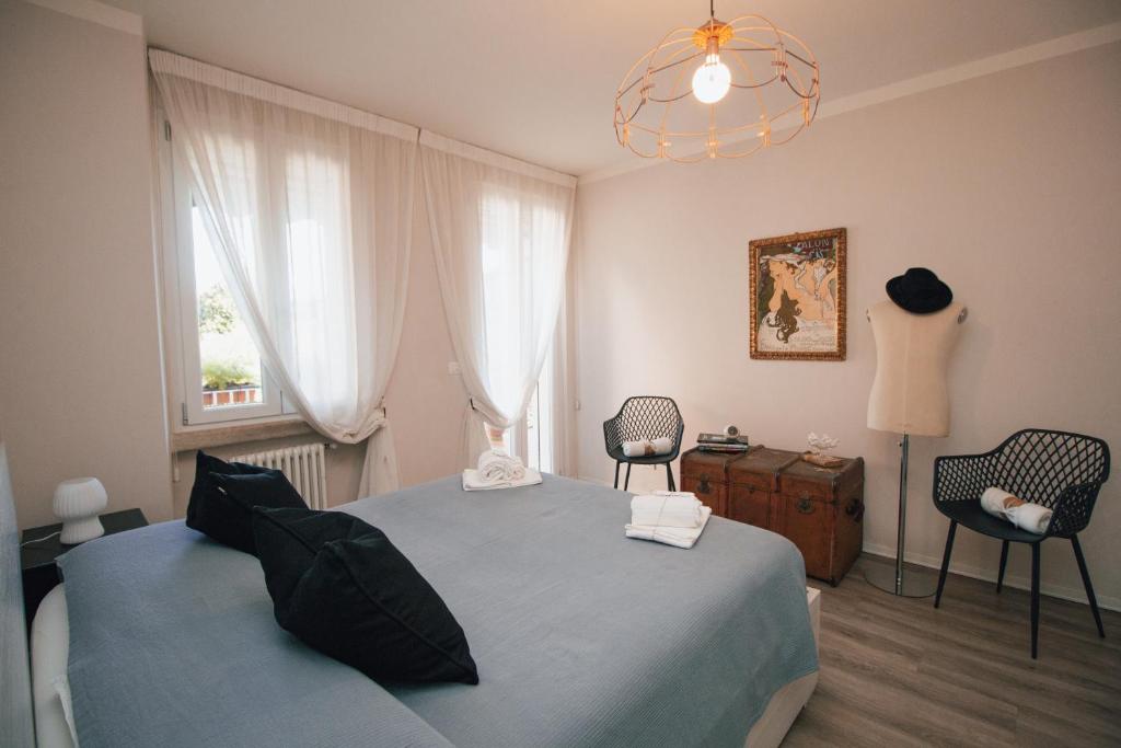 a bedroom with a bed and two chairs and a window at Rossanella's Home in Desenzano del Garda