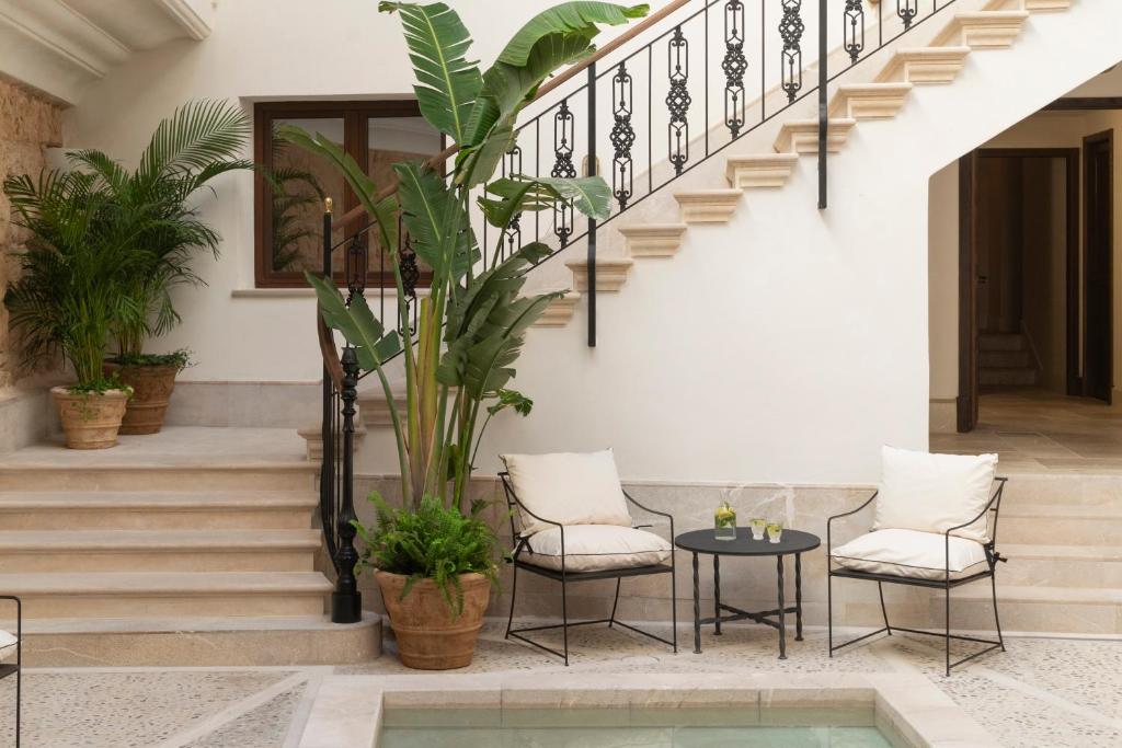 a courtyard with a table and chairs and stairs at Portella in Palma de Mallorca