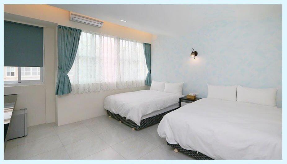 吉安的住宿－花蓮日森民宿，酒店客房设有两张床和窗户。