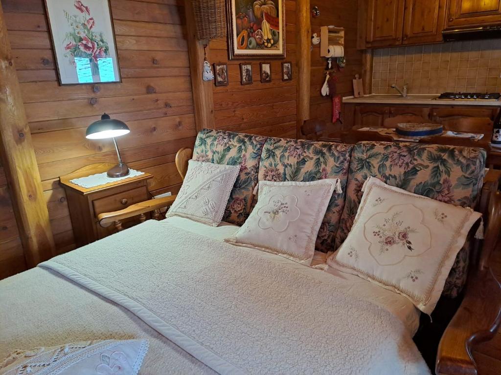 a bedroom with a bed with pillows and a couch at La casa nell'airetta in Balme
