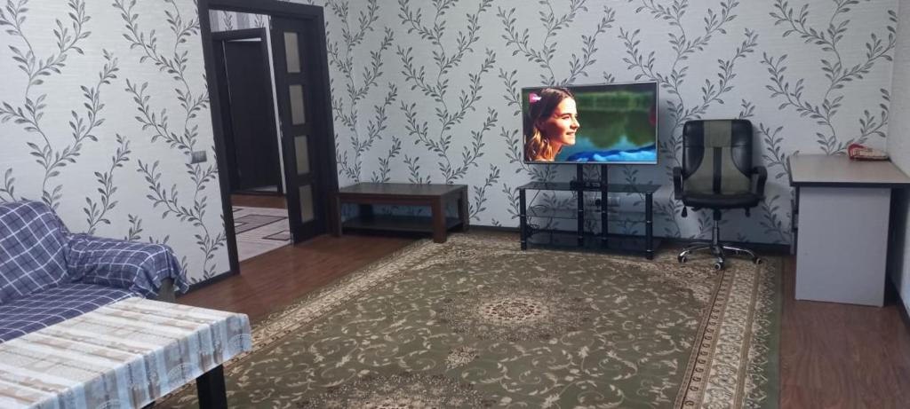 sala de estar con TV y sofá en Акбар Хакимов en Dushanbe