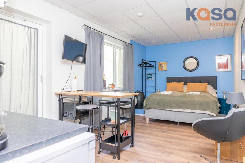 a bedroom with a bed and a table and a desk at CityCentral 81 in Akureyri