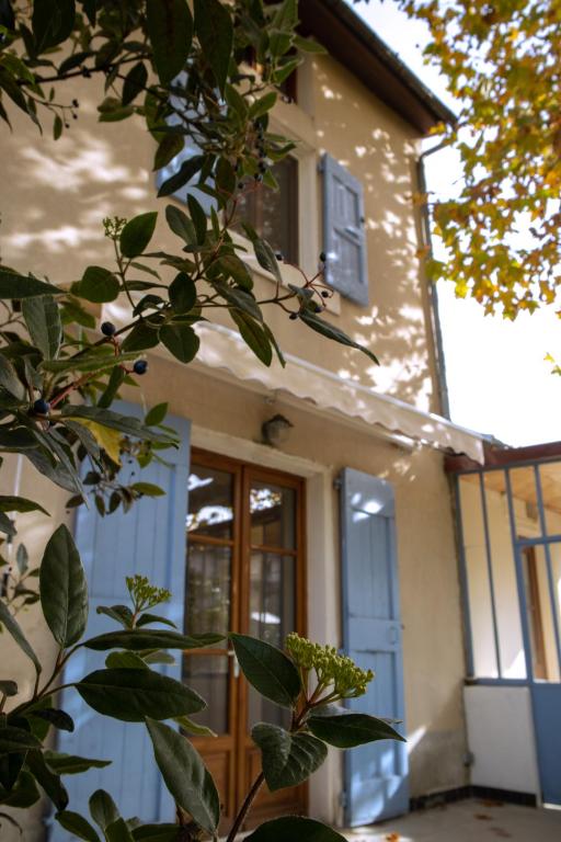une maison avec une porte et un arbre en face de celle-ci dans l'établissement La Maison Romanaise, à Romans-sur-Isère