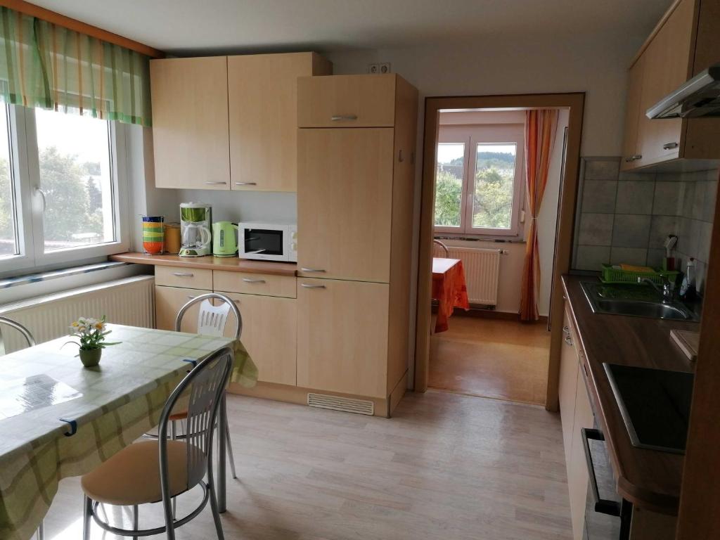 a kitchen with a counter and a table and chairs at Ferienwohnung Renner ca 100 qm in Mühlingen