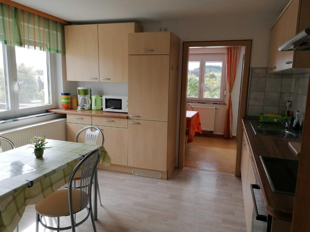 een keuken met een aanrecht, een tafel en stoelen bij Ferienwohnung Renner ca 100 qm in Mühlingen