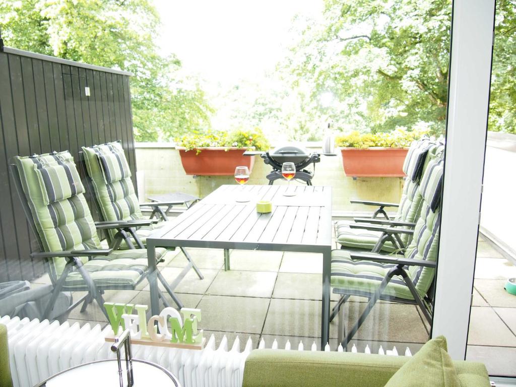 Un patio con sillas y una mesa en el balcón. en Apartment Harzgrün en Sankt Andreasberg