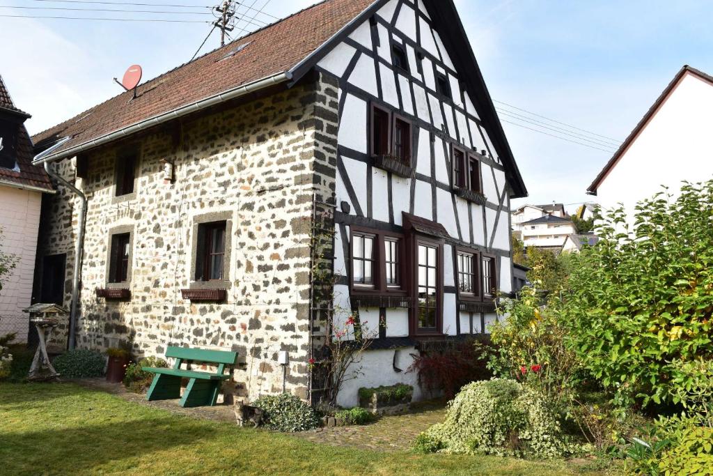 uma casa velha com um banco verde em frente em Das Pautzen Haus 