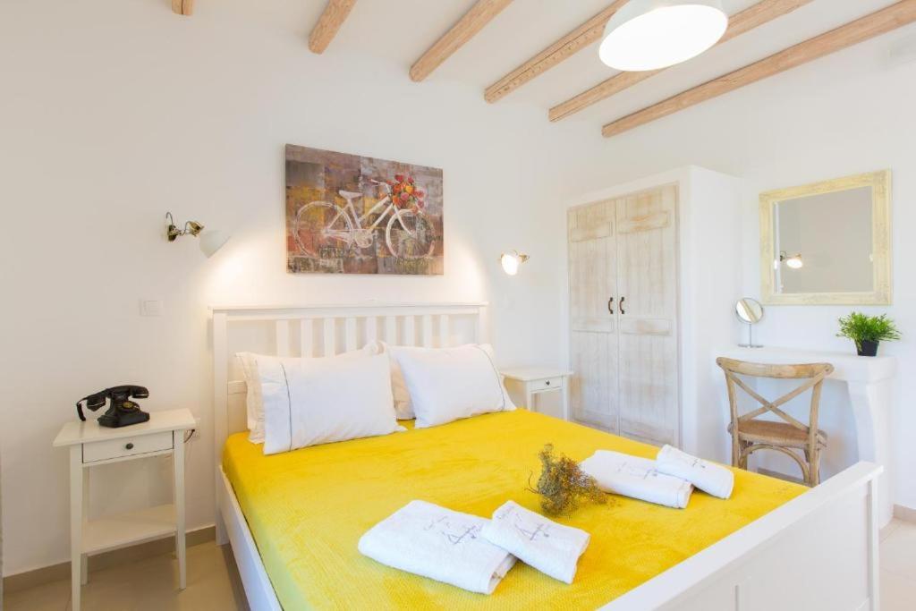 a bedroom with a large bed with two white pillows at Ampelos Plaka in Plaka