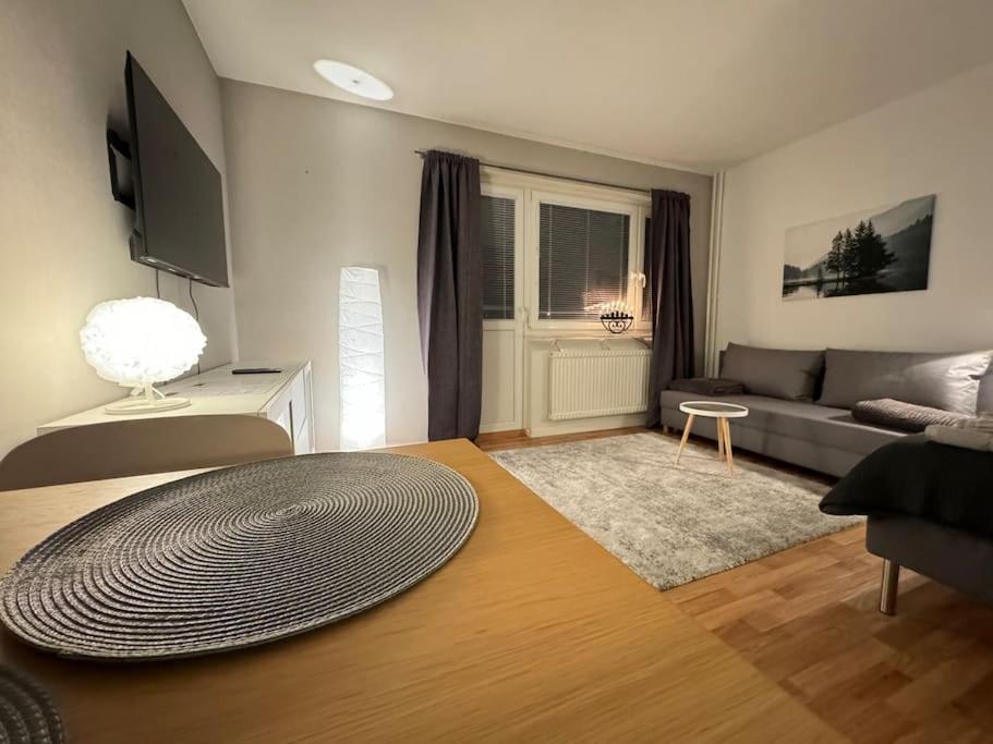 ein Wohnzimmer mit einem Sofa und einem Tisch in der Unterkunft Lägenhet i centrala Lidköping - MyHostel in Lidköping