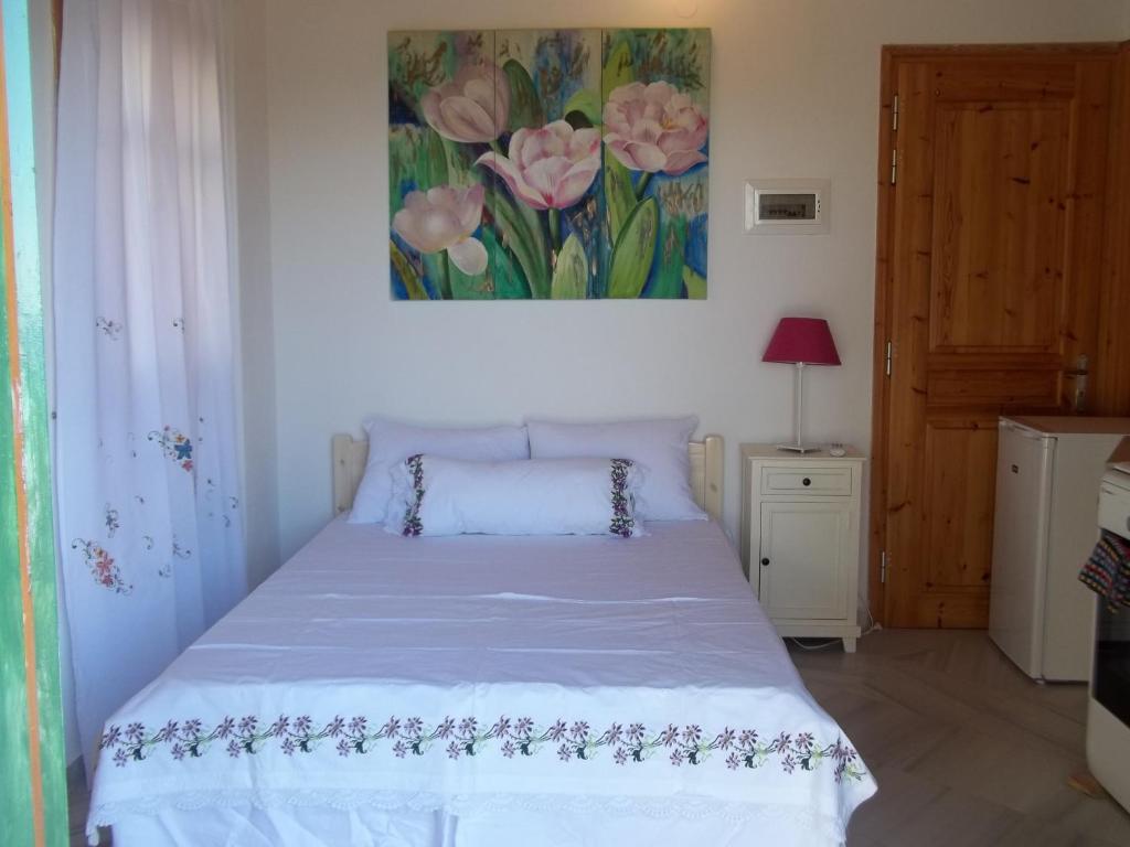 1 dormitorio con 1 cama y una pintura en la pared en zacharoularooms3, en Manganítis