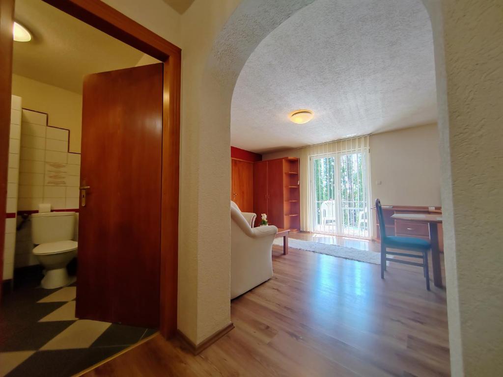 a hallway with a living room with a table at Hévíz Apartman Hévíz in Hévíz