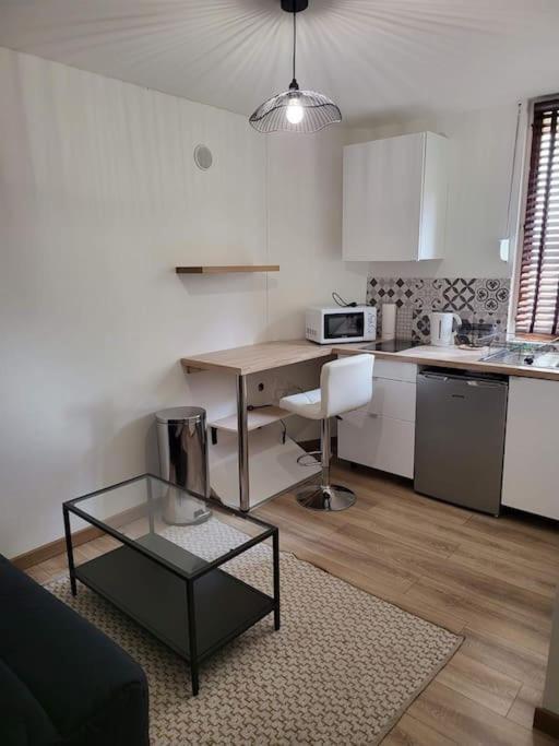 une cuisine avec un bureau, une table et une chaise dans l'établissement Le Chopin A côté de la gare, à Nancy