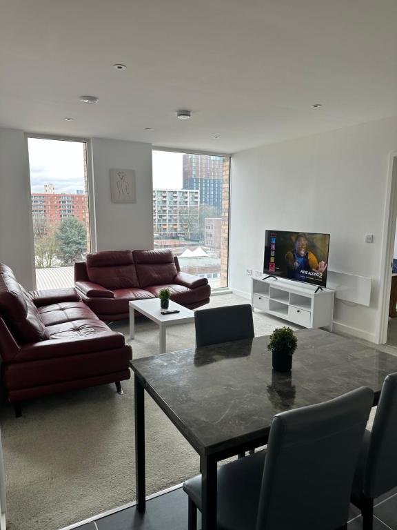 een woonkamer met een bank en een tv bij Central 2Bed Luxury Apartment in Manchester
