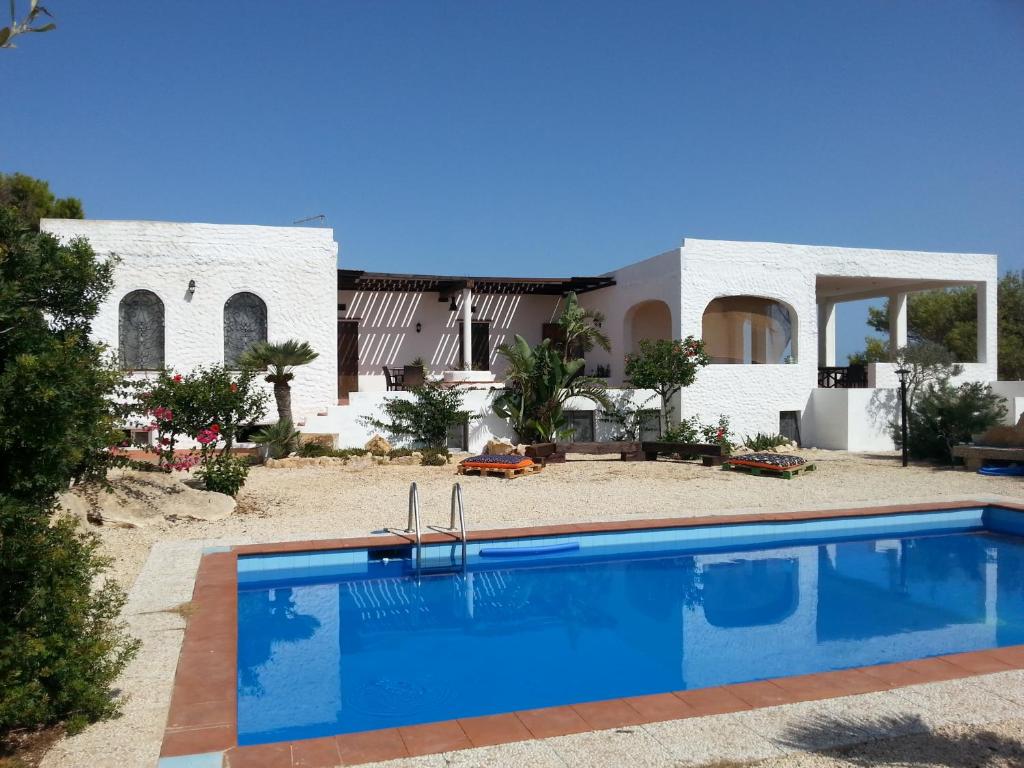 a villa with a swimming pool in front of a house at Villa Jeko in Lampedusa