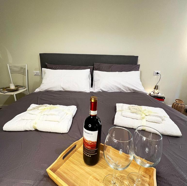 una bottiglia di vino e due bicchieri di vino su un letto di Lawyer House Milan a Milano