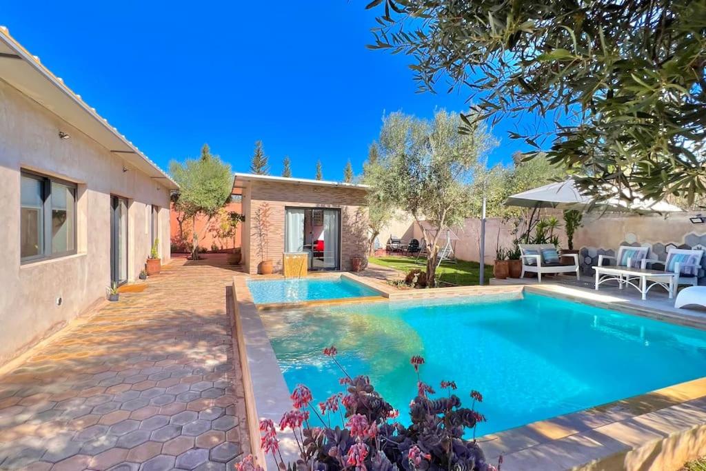 Villa Alambra Marrakech sur Atlas, Piscine privée في مراكش: مسبح في الحديقة الخلفية للمنزل