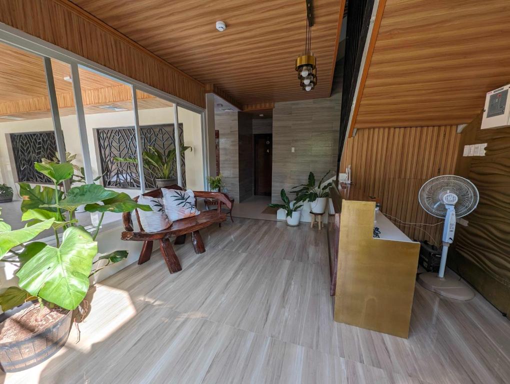 una sala de estar con ventilador y algunas plantas en OYO 1063 Manuela's Suites en Puerto Princesa