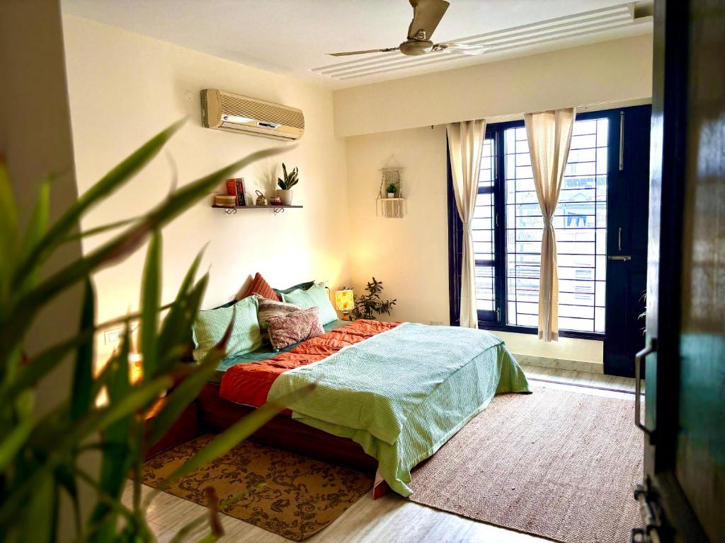 een slaapkamer met een bed en een plant bij Cozy Boho Suite in Sohāna