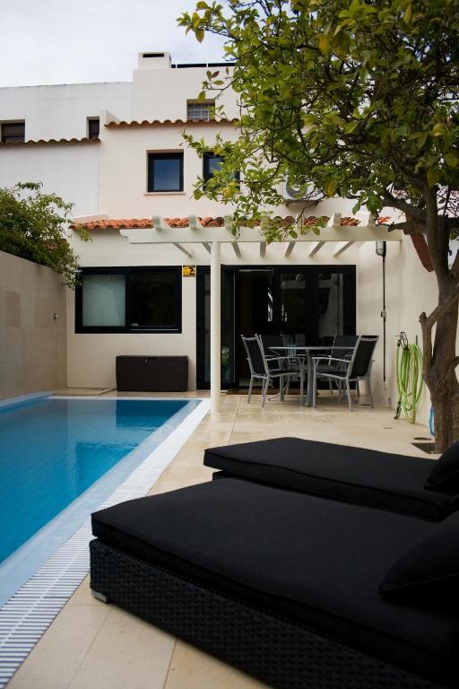 a backyard with a swimming pool and a house at BmyGuest - Vilamoura Marina's View in Vilamoura