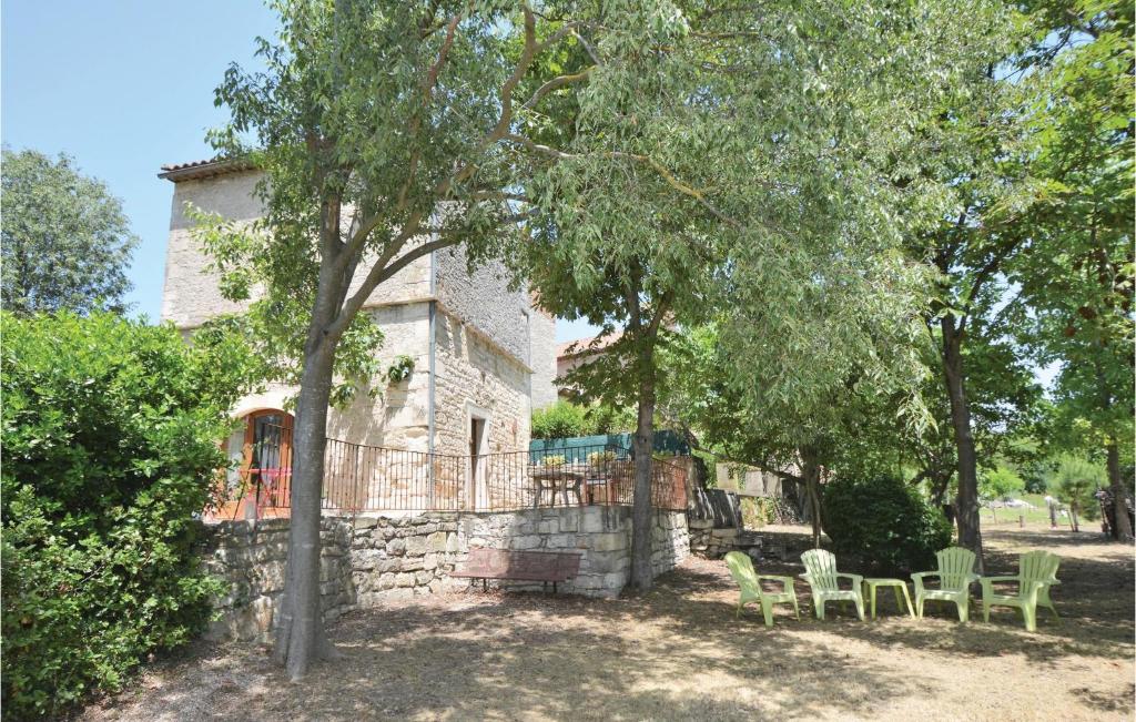 a stone house with green chairs in front of it at Amazing Home In Barjac With 3 Bedrooms, Wifi And Outdoor Swimming Pool in Barjac