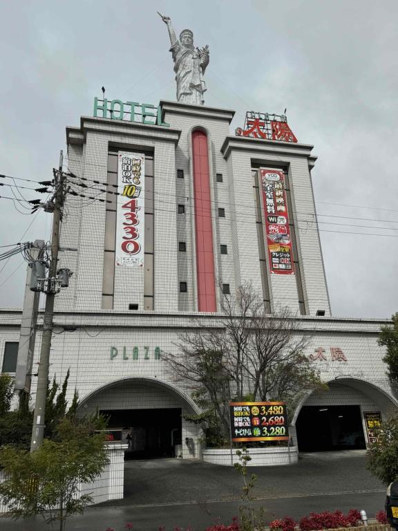 a building with a statue on top of it at プラザ太陽 in Ritto