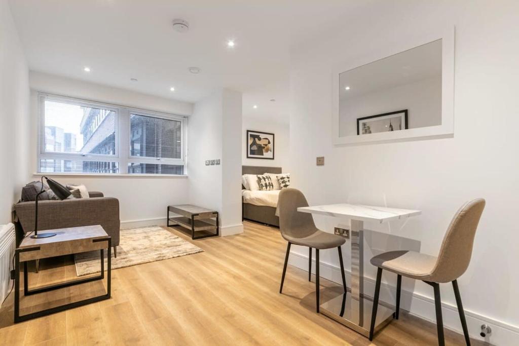 a living room with a couch and a table and chairs at Modern and Stylish Studio Apartment in East Grinstead in East Grinstead