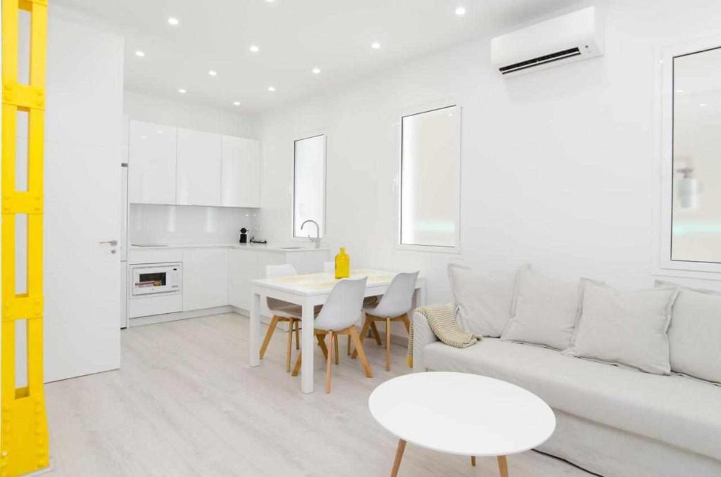 a white living room with a white couch and a table at We Madrid Casa Arriaza in Madrid