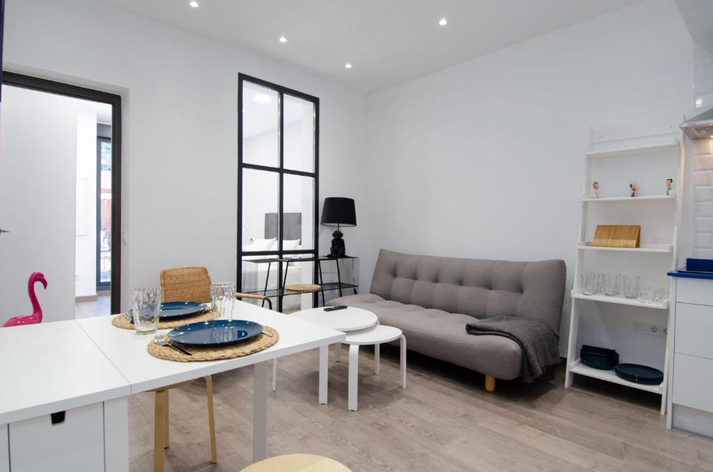 uma sala de estar com um sofá e uma mesa em We Madrid Casa Duque em Madrid