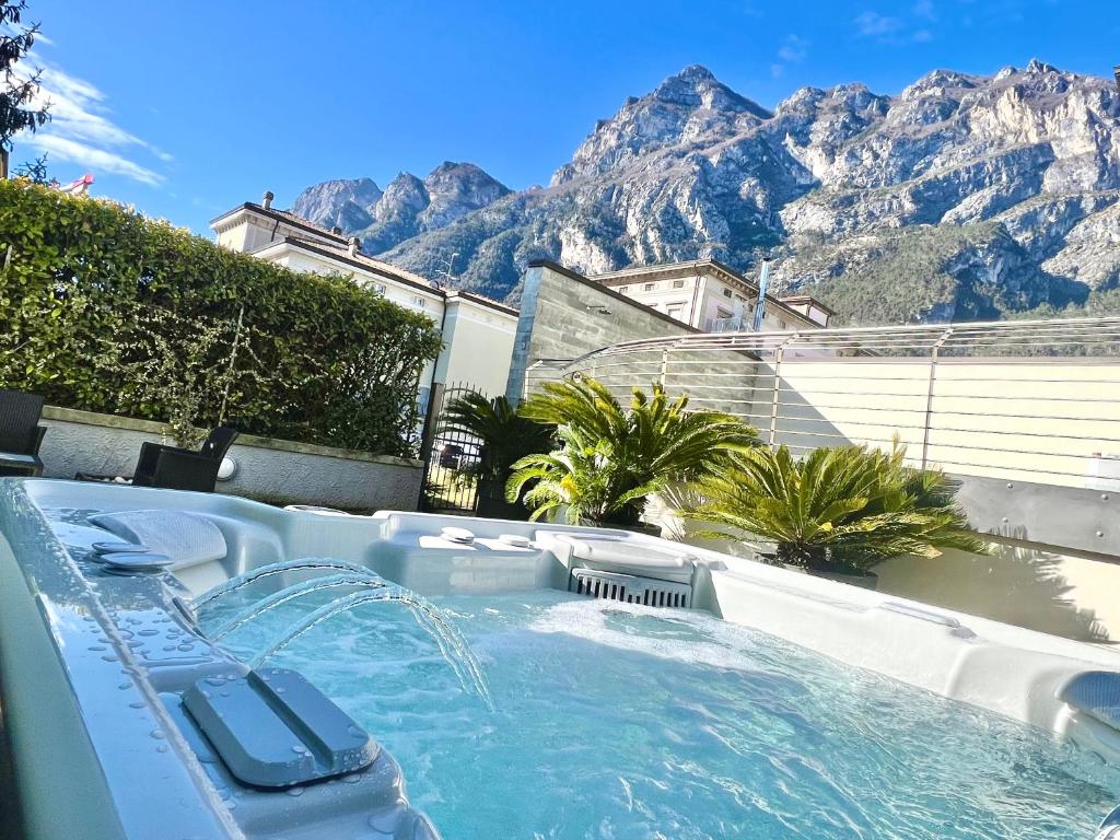 a pool with a water slide with mountains in the background at Residence Alle Palme in Riva del Garda