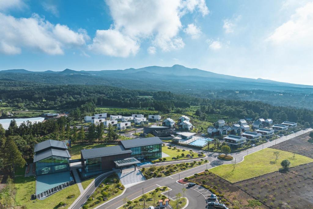 una vista aérea de una ciudad con montañas en el fondo en Yakmaeul en Seogwipo