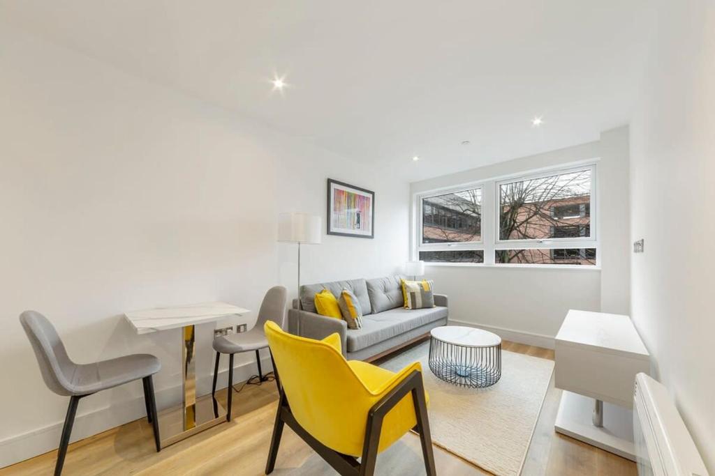 een woonkamer met een bank, een tafel en gele stoelen bij Modern and Stylish 1 Bed Apartment in East Grinstead in East Grinstead
