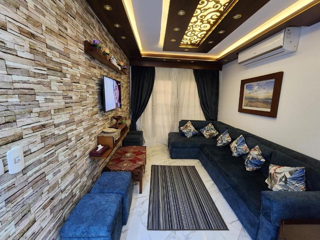 a living room with a couch and a stone wall at Porto said بورتوسعيد شاليه غرفه وصاله in Port Said