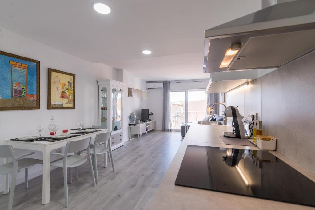 a kitchen and dining room with a table and chairs at Quimanna Calafell Beach in Calafell