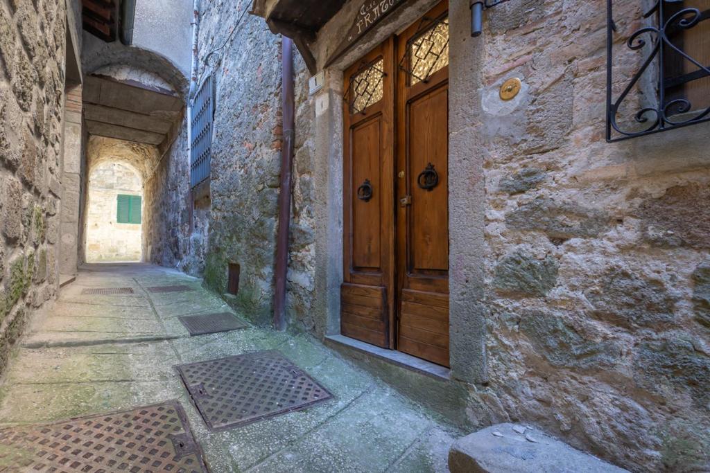 um beco com uma porta de madeira num edifício de pedra em Santa Fiora Ospitalità Diffusa - La Casa del Fratone em Santa Fiora