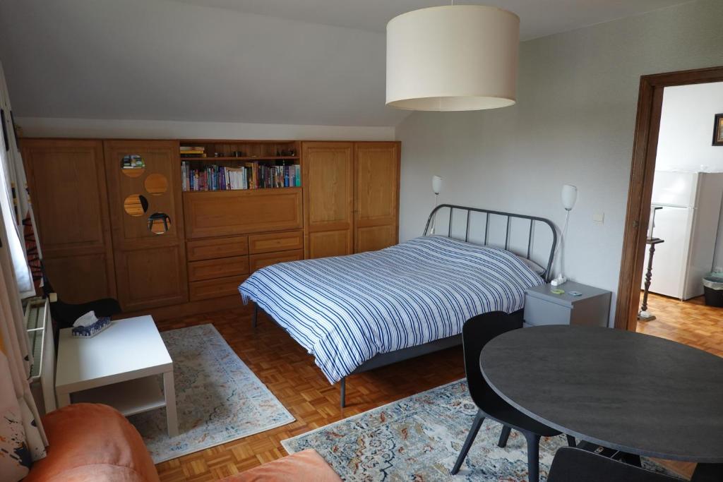 a small bedroom with a bed and a table at Logeren in Aldeneik in Maaseik