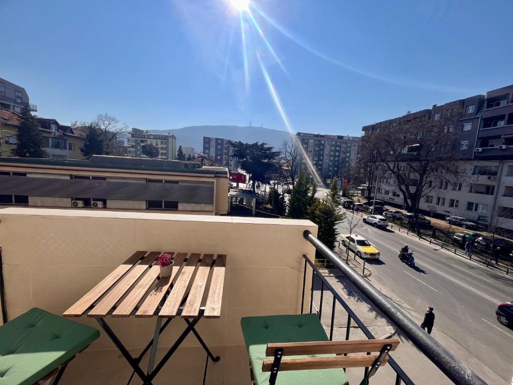een tafel en stoelen op een balkon met uitzicht op een straat bij Roosevelt apartment in Skopje