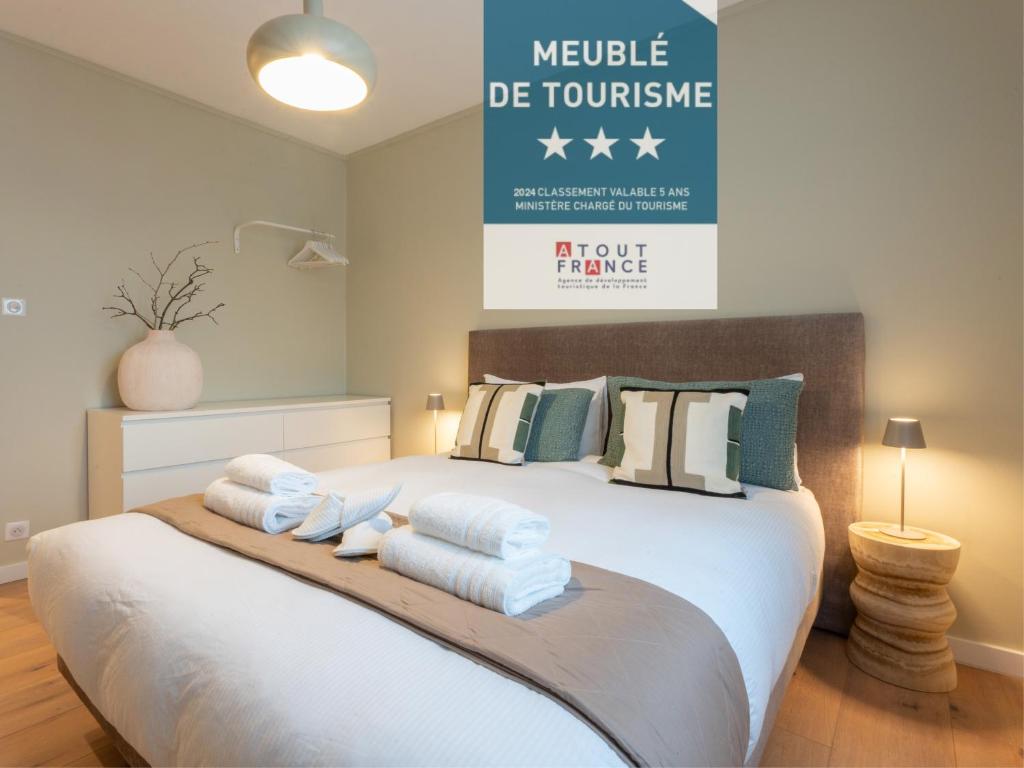 um quarto com uma cama grande e toalhas em LE N'ESPRESSO em Mulhouse