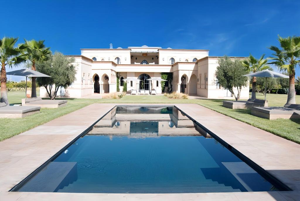 un domaine avec une piscine en face d'un bâtiment dans l'établissement Palais Laawina, à Marrakech