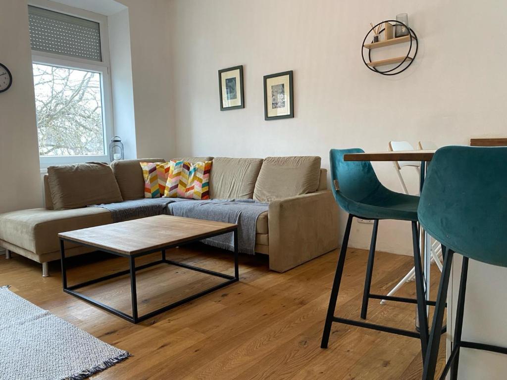 uma sala de estar com um sofá, uma mesa e cadeiras em Altbau mit Flair em Klagenfurt