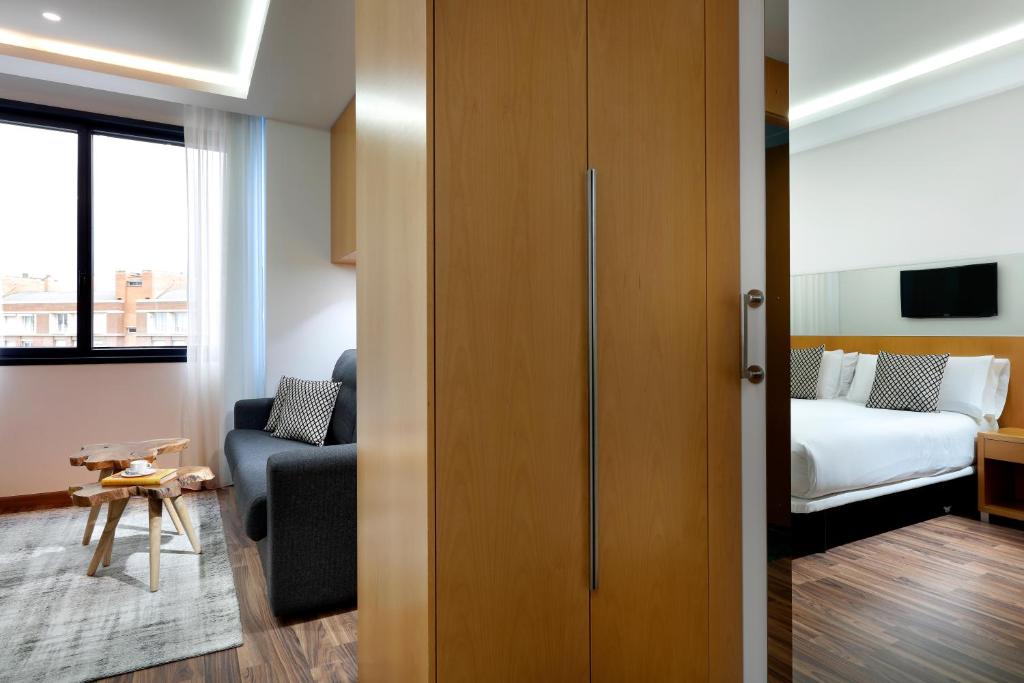 a hotel room with a bed and a couch and a bedroom at Hotel SB Icaria in Barcelona