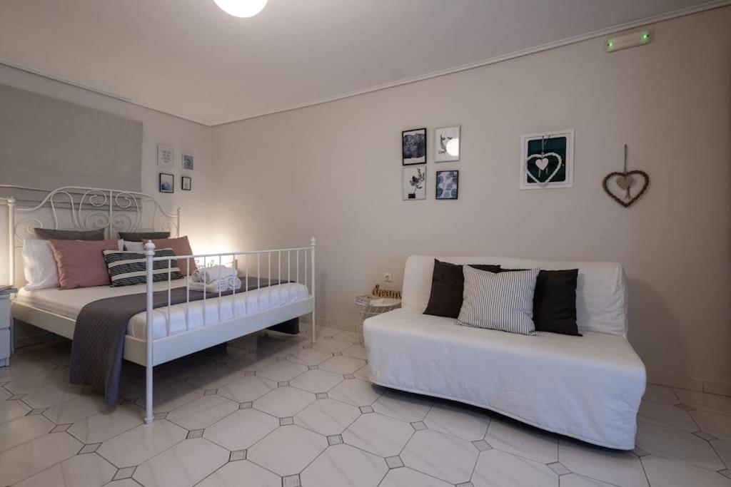 a bedroom with two beds and a bench in it at Elysian Studio in Kalamata