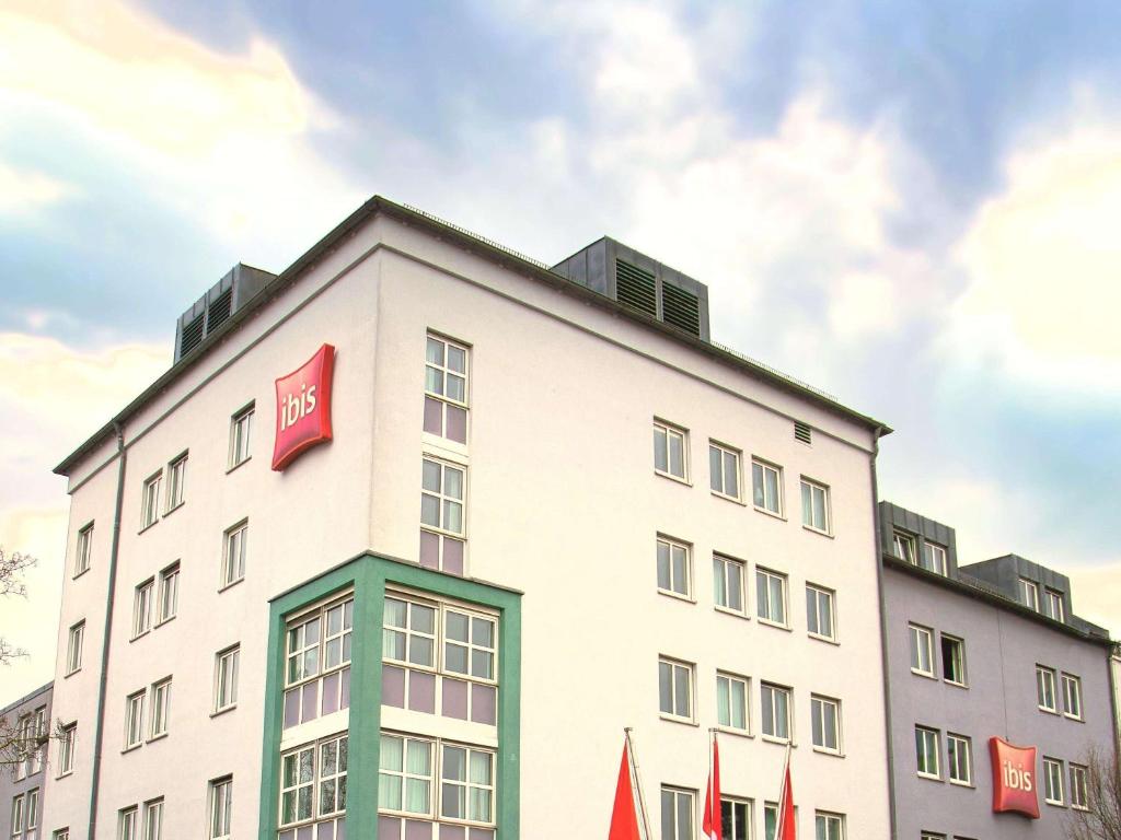 ein großes weißes Gebäude mit einem roten Schild darauf in der Unterkunft ibis Hotel Regensburg City in Regensburg
