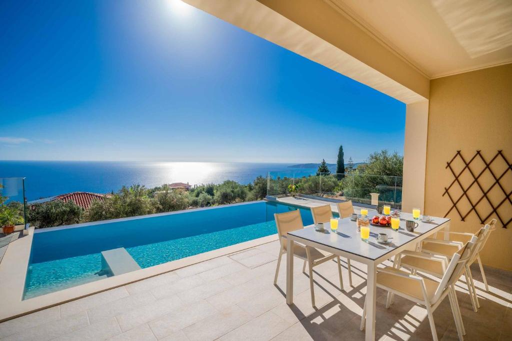 a villa with a swimming pool and a dining table at Villa Andriana in Vlachata
